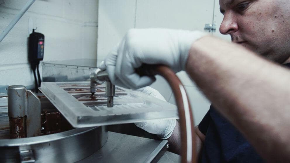 O chocolateiro premiado que trabalha em uma pequena oficina com máquinas improvisadas